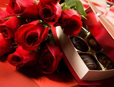 Red rose with heart shaped box of chocolate
