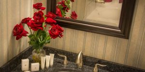 Buckingham Room bathroom vanity with red roses in a vase